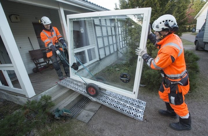 Tiivin ikkuna-asentajat siirtävät huolellisesti ikkunaa Helsinkiläiseen rivitaloyhtiöön